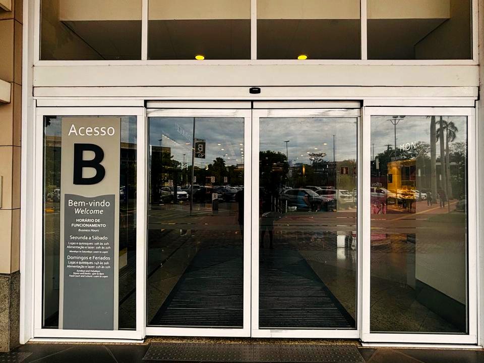 Acesso de shopping center com conjunto de portas automáticas de vidro ao entardecer