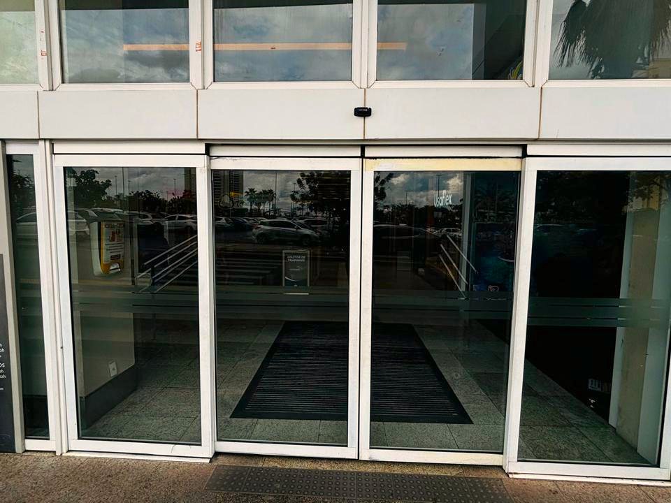 Fachada de shopping com conjunto de portas automáticas de vidro